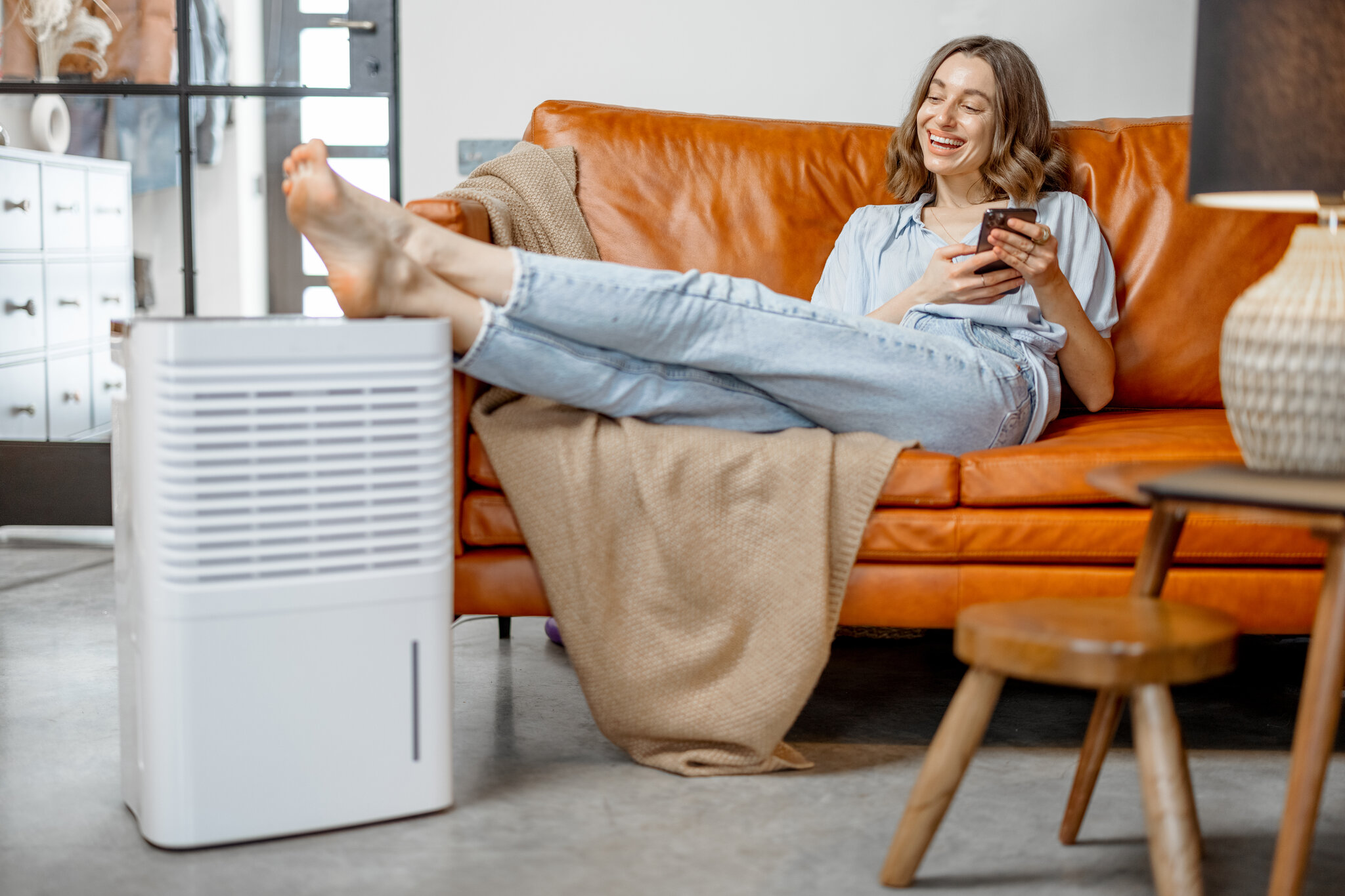 woman sitting next to air purifier